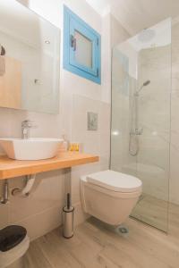 a bathroom with a toilet and a sink and a shower at Akrotiri Vasiliki in Vasiliki