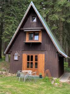 a house with a table and chairs in front of it at Chata u Vachtů in Kubova Huť