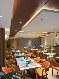 a restaurant with tables and chairs and people in the background at Hotel Rodolfo in Tacloban
