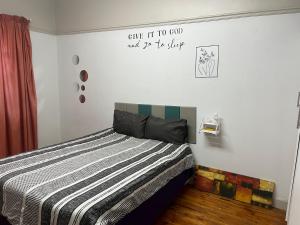 a bedroom with a bed and a sign on the wall at The Willow Whispers guest house in Gqeberha