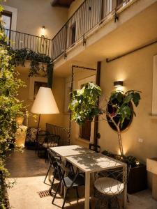 a patio with a table and a potted plant at Albergo Diffuso Ginevra Boutique Rooms - Palazzo Leosini - Residenze D'Epoca in LʼAquila