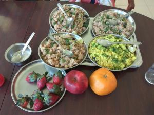 a table topped with bowls of food and strawberries at Nature Trinity House in Panchgani