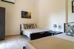 a room with two beds and a chair in it at Akrogiali Studios Michaniona in Nea Michaniona
