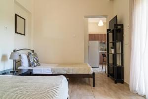 a small room with two beds and a refrigerator at Akrogiali Studios Michaniona in Nea Michaniona