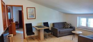 a living room with a couch and a table and a chair at Apartmani Volme in Banjole