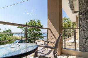 a balcony with a table and a view of the ocean at Akrogiali Studios Michaniona in Nea Michaniona +68 photos