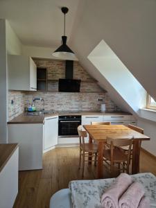 a kitchen with white cabinets and a wooden table at Domačija Blaževc in Žiri