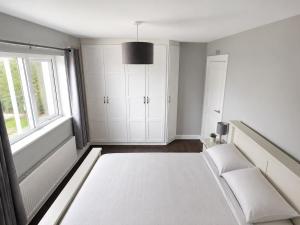 a white room with a bed and a window at Hill house Westport in Castlebar