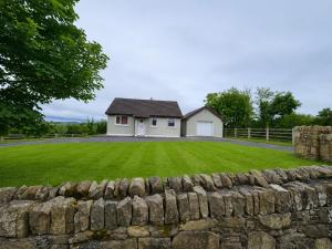 a house with a stone wall in front of a yard at Hill house Westport in Castlebar