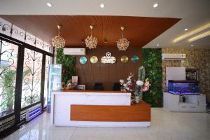 a lobby with a reception desk and flowers on the wall at Hotel Vantara in Karnāl