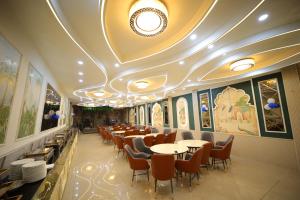 a restaurant with tables and chairs and a ceiling at Hotel Vantara in Karnāl