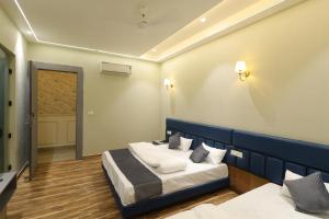 a hotel room with two beds and a door at Hotel Vantara in Karnāl +10 photos