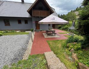a patio with a picnic table and an umbrella at Chata u Vachtů in Kubova Huť +7 photos