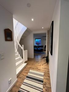 a hallway with a staircase and a living room at Senja Aurora Lodge in Senja