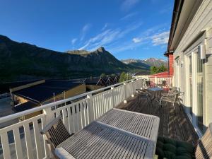 a balcony with two chairs and a table with mountains at Senja Aurora Lodge in Senja