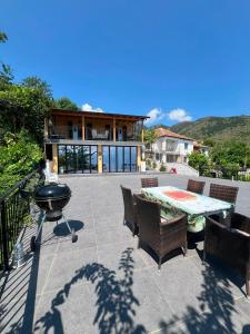 a patio with a grill and a table and chairs at Vila 4 Stinet in Pogradec