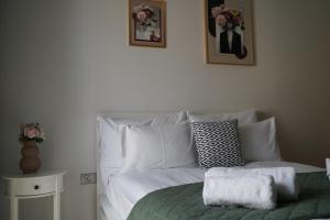 a bed with white pillows and a green blanket at Titanium in Izola