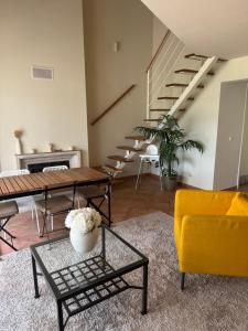 a living room with a table and a yellow couch at Aroeira Elite Apartments in Aroeira