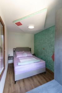a bedroom with a bed with a green wall at Apartman Smaragd Lux in Plužine