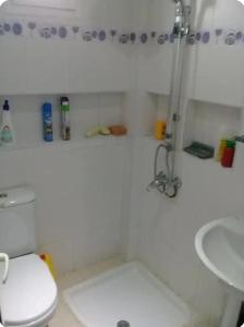 a white bathroom with a toilet and a sink at l'Olivier in La Goulette