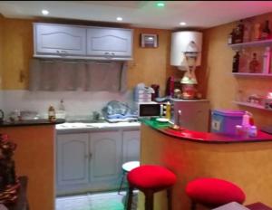 a kitchen with a counter and red stools in it at l'Olivier in La Goulette