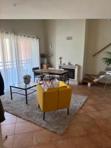 a living room with a yellow couch and a table at Aroeira Elite Apartments in Aroeira +18 photos