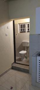 a bathroom with a toilet inside of a room at UV Apartment in Lilongwe