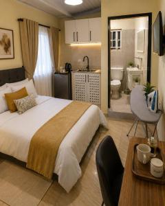 a bedroom with a large bed and a bathroom at UV Apartment in Lilongwe