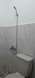 a bathroom with a white toilet with a shower at Mutiara Guest House Syariah in Padangluar +41 photos