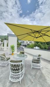 a yellow umbrella on a patio with chairs and a table at PARALLEL Apartments in Gonio
