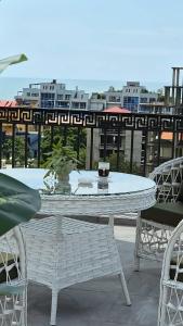 a white table and chairs on top of a balcony at PARALLEL Apartments in Gonio
