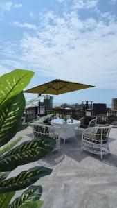 a table and chairs with an umbrella on a roof at PARALLEL Apartments in Gonio