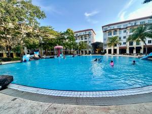a large swimming pool with people in the water at Tiara Homestay Desaru - Garden Pool View in Bandar Penawar
