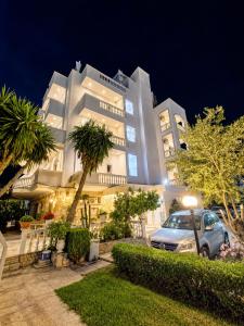 a building with a car parked in front of it at Vasiliu Boutique Hotel Ksamil in Ksamil