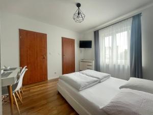 a bedroom with a bed and a desk and a window at D.W. JULIA in Władysławowo