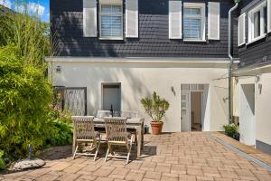 a patio with a table and chairs in front of a house at Mola Apartments- Trendiges Apartment in der City-Nähe Dortmund-Terrasse-3 Gäste-WLAN in Herdecke