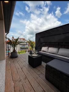 a patio with a couch and a table on a deck at Ferienwelt Wittenberge in Wittenberge
