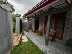 a patio with two chairs and a house at Casa Bella Home in Ja-Ela