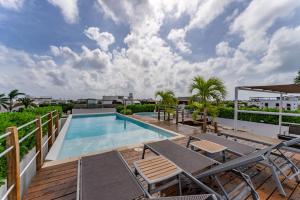 a swimming pool on a balcony with chairs and a deck at Downtown Playa close 5th Av Rooftop Pool in Playa del Carmen