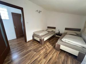 zwei Betten in einem Zimmer mit Holzboden in der Unterkunft Catana in Arad