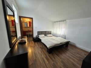 ein Schlafzimmer mit einem Bett, einem Tisch und einem Spiegel in der Unterkunft Catana in Arad