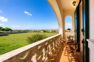 a balcony with a table and a view of a field at Monte Cuccu Bed & Breakfast in Cerfignano