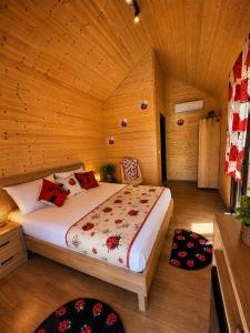 ein Schlafzimmer mit einem Bett in einem Holzzimmer in der Unterkunft Lean chalet Sea&Mountain view in Dukat