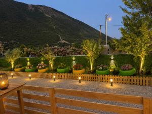 ein Garten mit Kerzen, Blumen und einem Zaun in der Unterkunft Lean chalet Sea&Mountain view in Dukat
