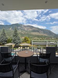 a patio with a table and chairs and mountains at Hotel Iliana in Mandrotopos