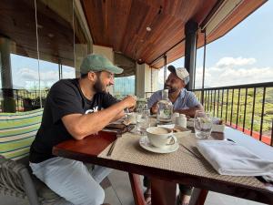 two men sitting at a table in a restaurant at SEVENSTAR RESIDENCY in Varkala