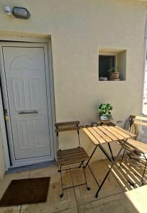 a wooden bench next to a door with a plant at Nára house 3 in Spata