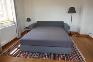 a bed in a room with a couch and a rug at Lerchenhof in Balingen