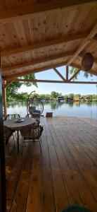 a wooden deck with a table and chairs on a lake at Kucica Janja in Ulcinj