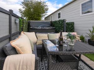 a patio with a table and chairs and a grill at Sunset Lodge in Warkworth
